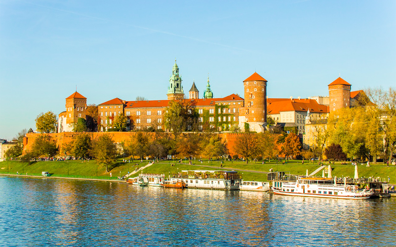 Wawel Castle in Krakow with boats on the Vistula River.