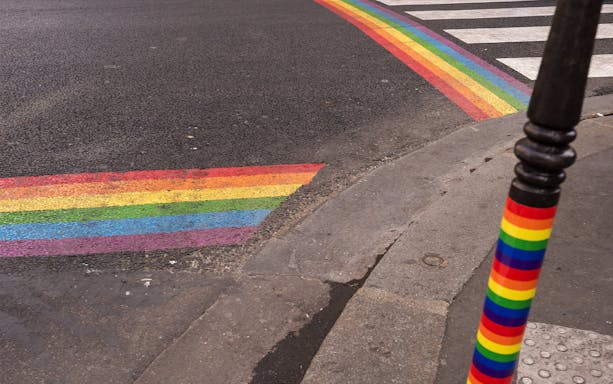 Rainbow crosswalk and pole in Le Marais, Paris, on a walking tour route.