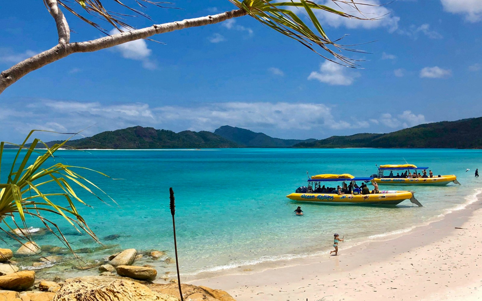 Yellow rafts on Whitsundays beach with turquoise water and distant islands.