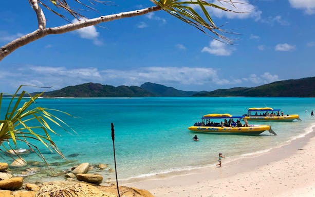 Yellow rafts on Whitsundays beach with turquoise water and distant islands.