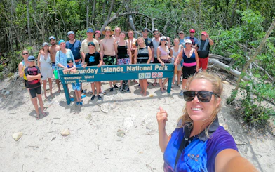 Group at Whitsunday Islands National Park sign during Fly + Raft tour.
