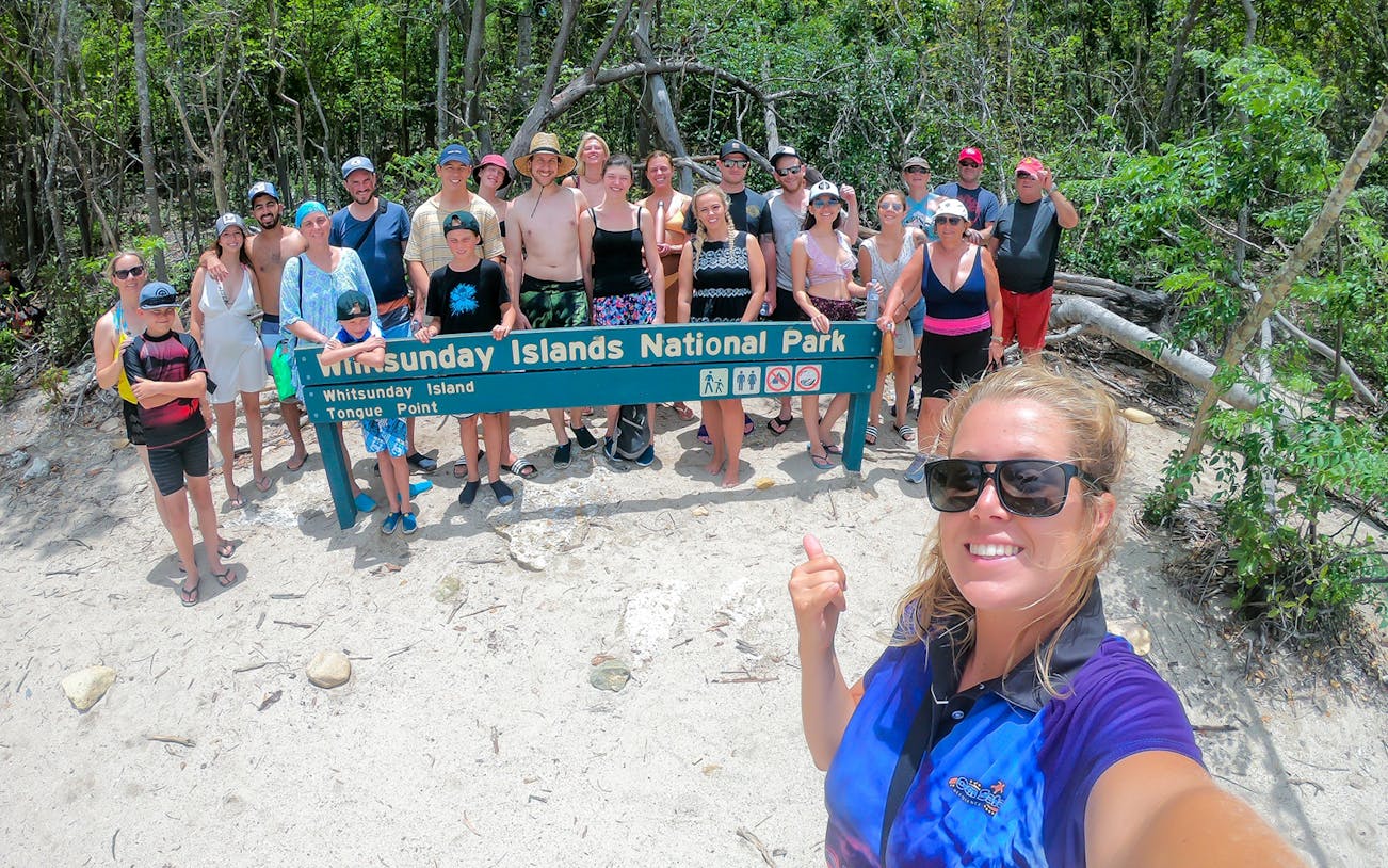 Group at Whitsunday Islands National Park sign during Fly + Raft tour.