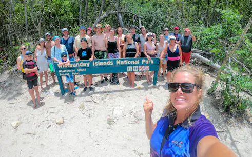 Group at Whitsunday Islands National Park sign during Fly + Raft tour.
