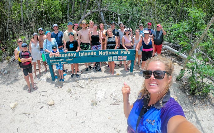 Group at Whitsunday Islands National Park sign during Fly + Raft tour.
