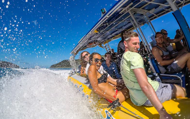 Group enjoying a speedboat ride in the Whitsundays, part of the Fly + Raft Package.