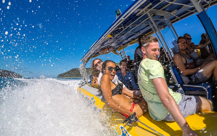 Group enjoying a speedboat ride in the Whitsundays, part of the Fly + Raft Package.