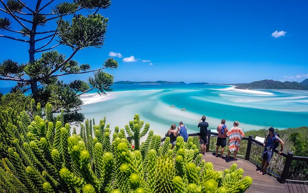 Tourists viewing Hill Inlet's turquoise waters and white sands in Whitsundays, Australia.