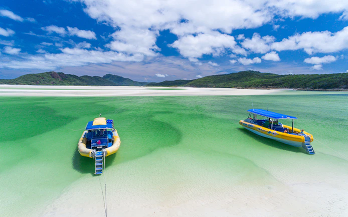 Two yellow rafts on clear green water at Whitehaven Beach, Whitsundays.