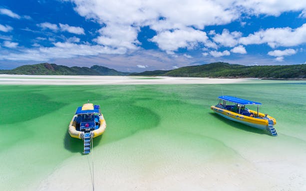 Two yellow rafts on clear green water at Whitehaven Beach, Whitsundays.