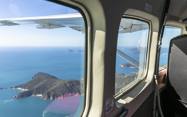 Aerial view of Whitsunday Islands from scenic flight window.