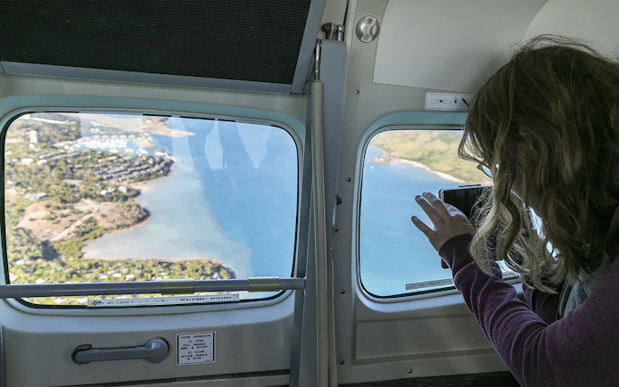Aerial view of Whitsundays coastline from scenic flight window.