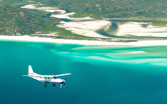 Scenic flight over Whitsundays with view of turquoise ocean and white sand beaches.