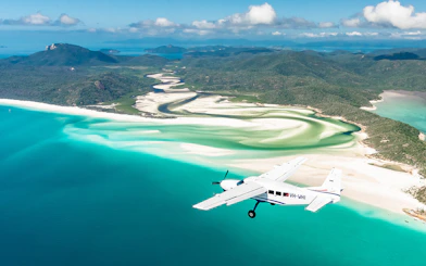 Aerial view of Whitsundays with scenic flight over turquoise waters and white sand beaches.