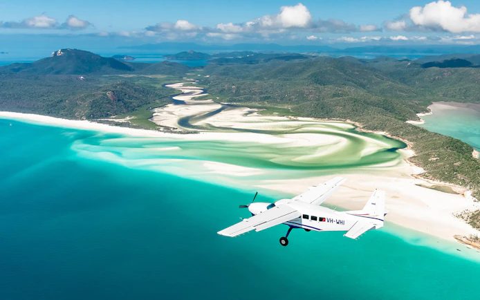 Aerial view of Whitsundays with scenic flight over turquoise waters and white sand beaches.