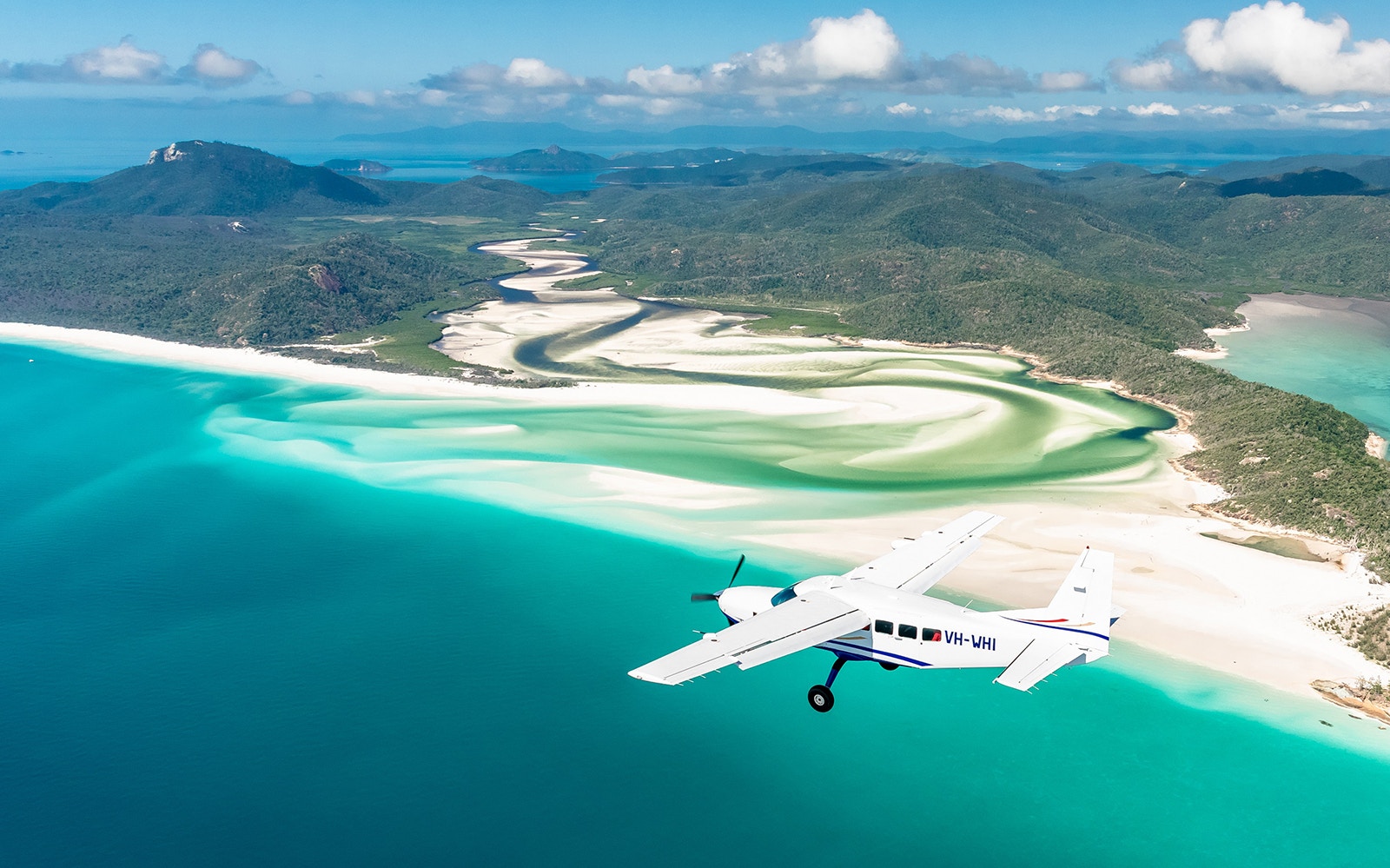 Aerial view of Whitsundays with scenic flight over turquoise waters and white sand beaches.