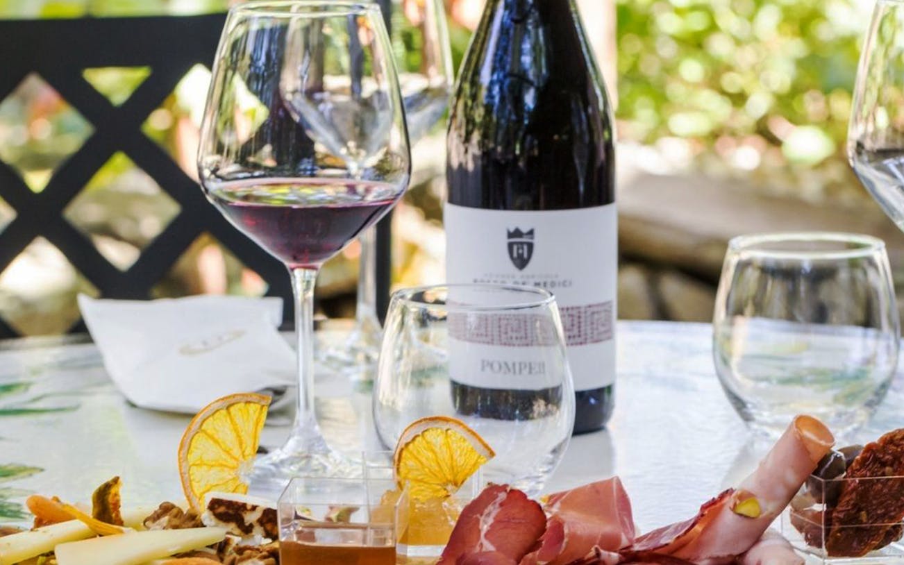 Wine and charcuterie on a table in Pompei, Italy, part of a Rome day trip.