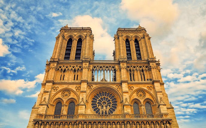 Notre-Dame Cathedral facade under a blue sky, Paris Latin Quarter.