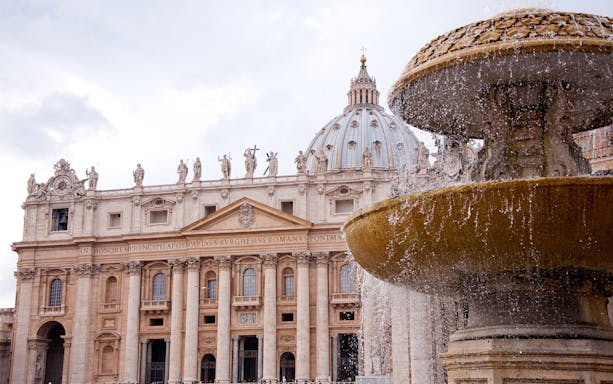 St. Peter's Basilica facade with fountain in Vatican City.
