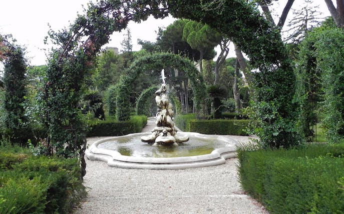 Fountain and archway in Vatican Gardens, Rome, on guided tour to St. Peter's Basilica.