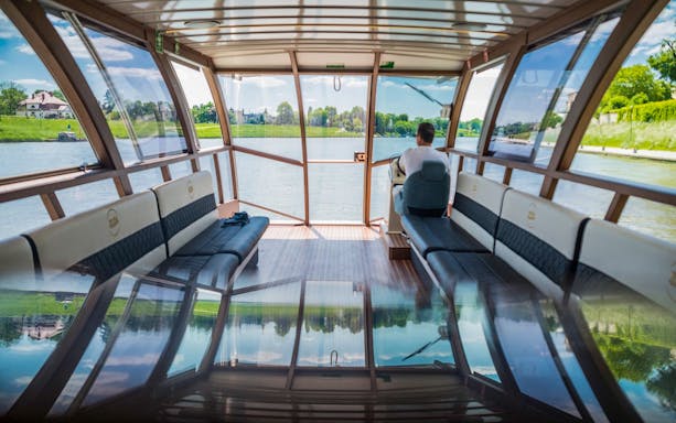 Interior of a boat on the Vistula River in Krakow, with a view of the riverbank.