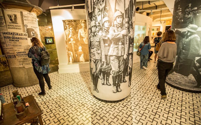 Visitors exploring historical exhibits at Plaszow concentration camp museum.