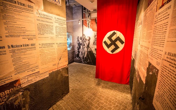 Historical documents and Nazi flag in Plaszow concentration camp exhibit.