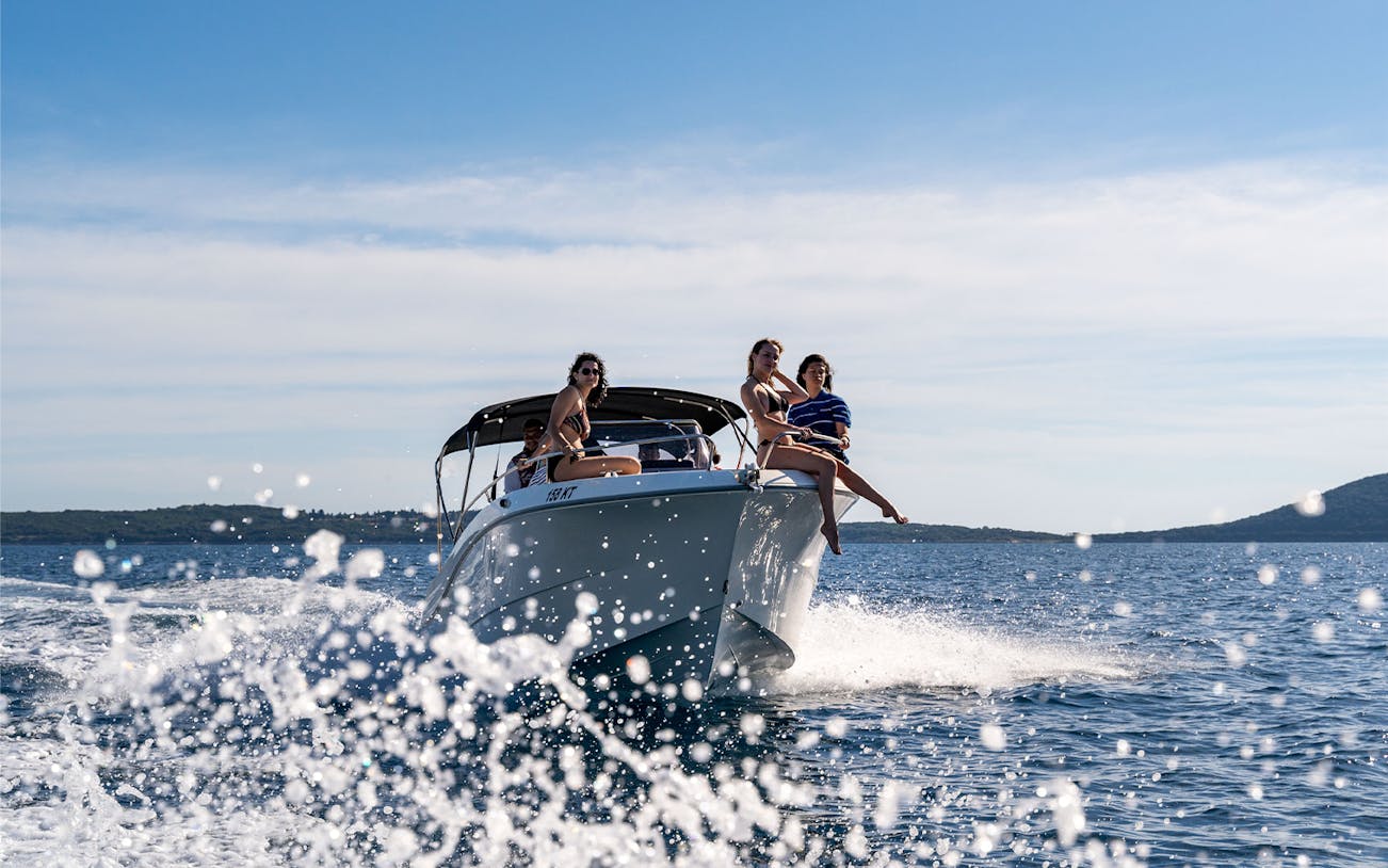 Private speedboat with passengers cruising Kotor Bay.