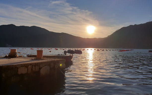 Sunset view over Kotor Bay with dock and buoys, Montenegro.