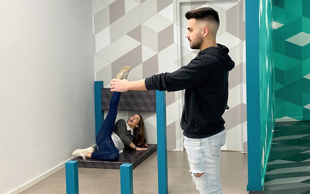 Man and woman interacting with optical illusion exhibit at Museum of Illusions, Thessaloniki.