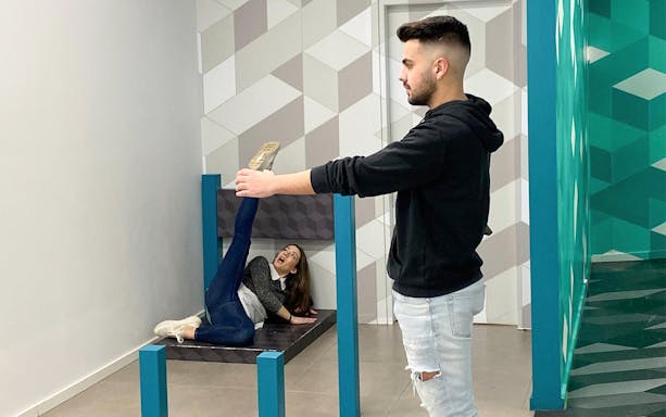 Man and woman interacting with optical illusion exhibit at Museum of Illusions, Thessaloniki.