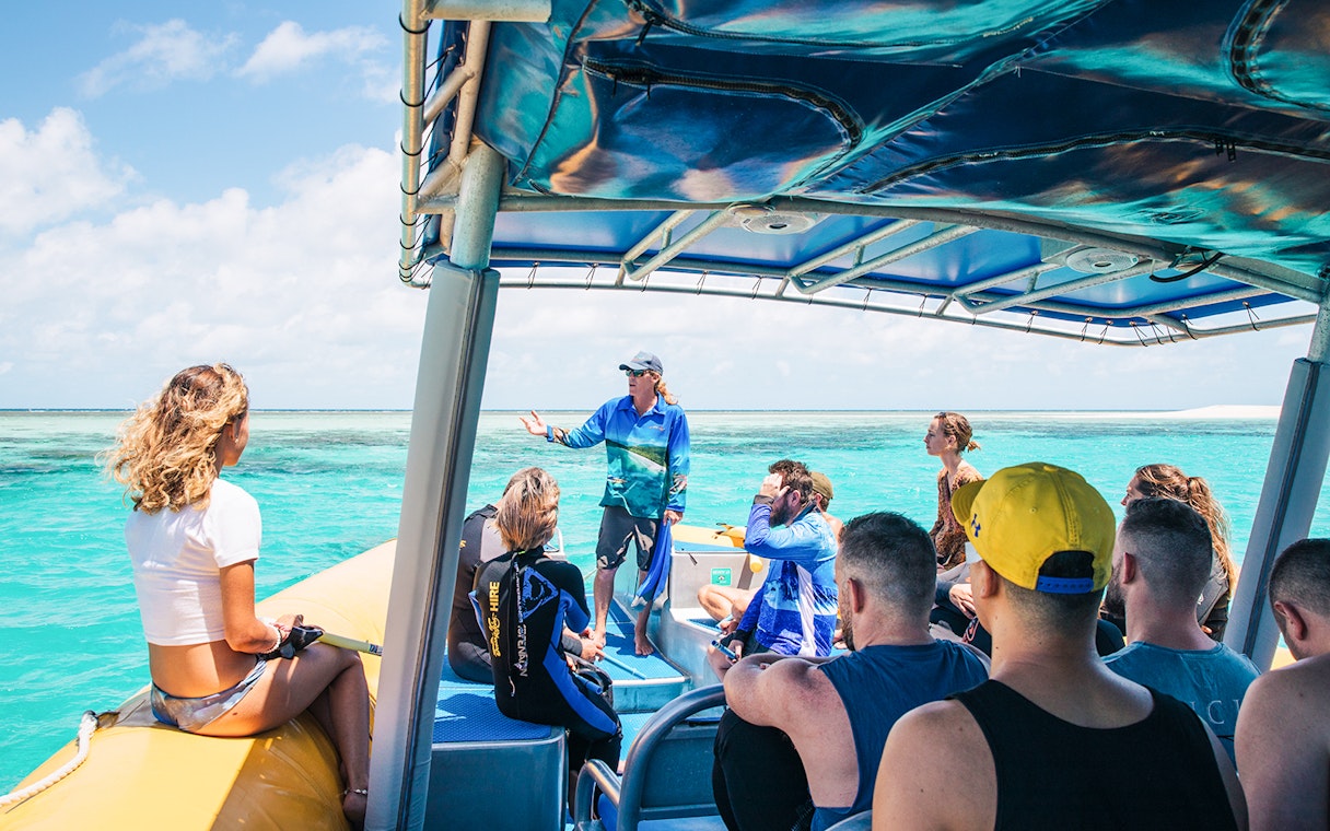 Tour group on a boat with guide during Ocean Safari Tour-9, exploring clear blue waters.