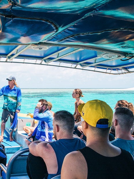 Tour group on a boat with guide during Ocean Safari Tour-9, exploring clear blue waters.