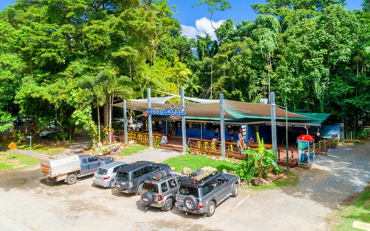 Ocean Safari Tour base with parked vehicles and lush greenery.