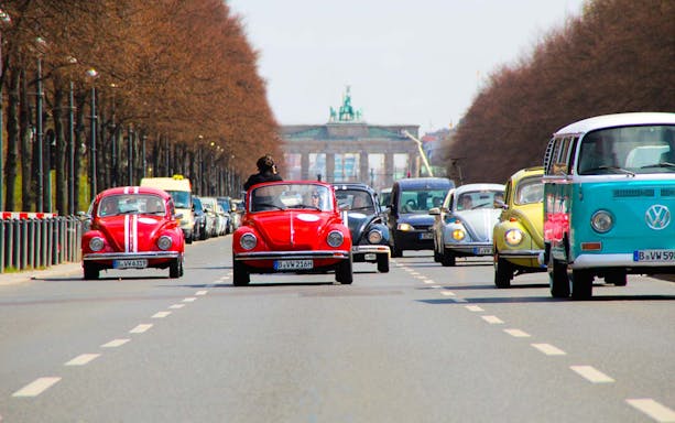 VW Beetle convertibles driving near Brandenburg Gate, Berlin on a discovery tour.