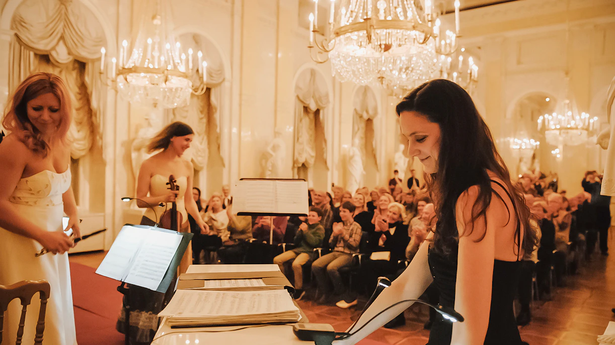 Musicians performing at Vienna Supreme Concerts with audience in elegant hall.