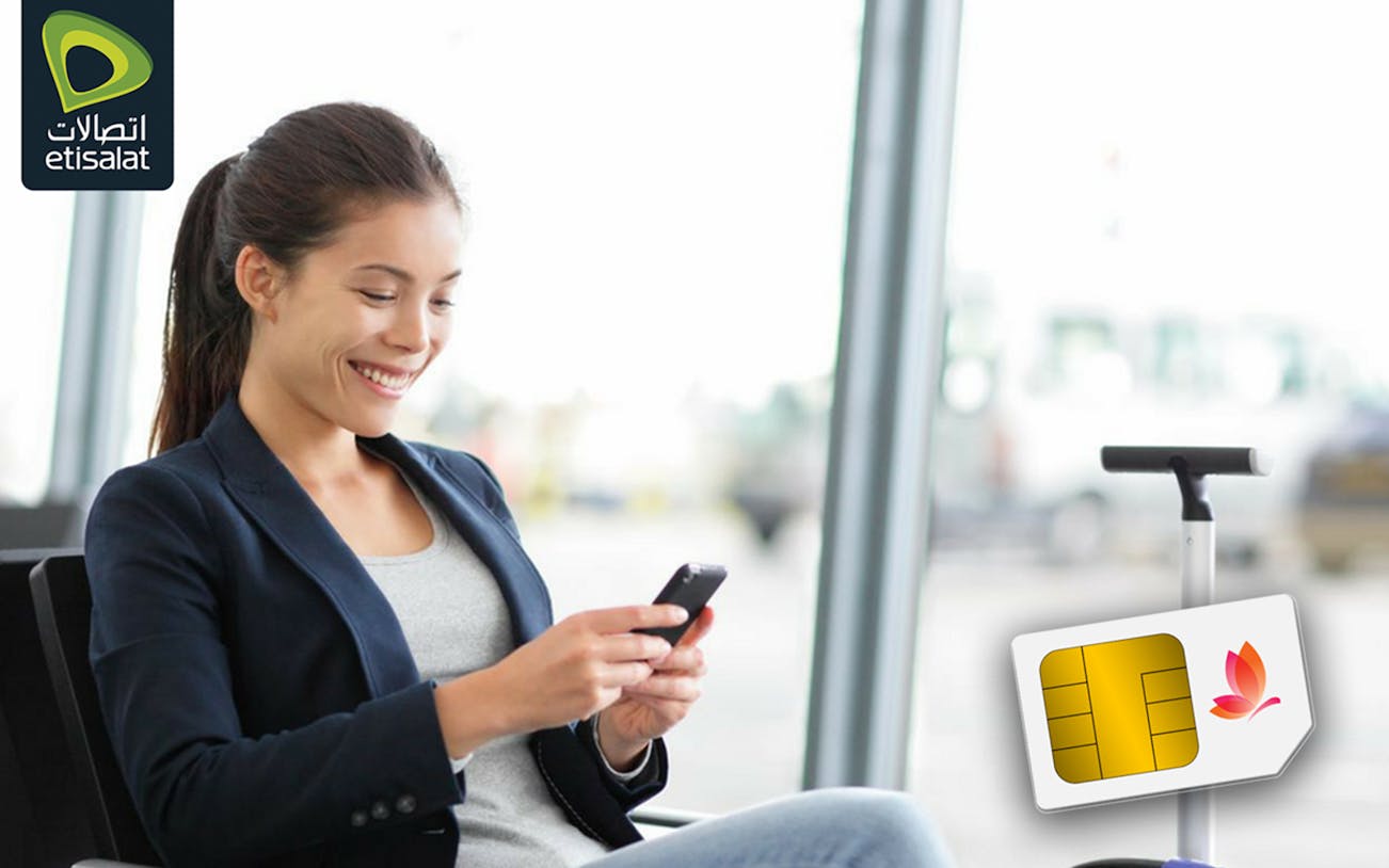 Traveler using phone with Etisalat SIM card at Sharjah Airport.