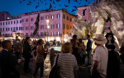 Crowd at Rome's Piazza Navona near the Fountain of the Four Rivers during ghost tour.
