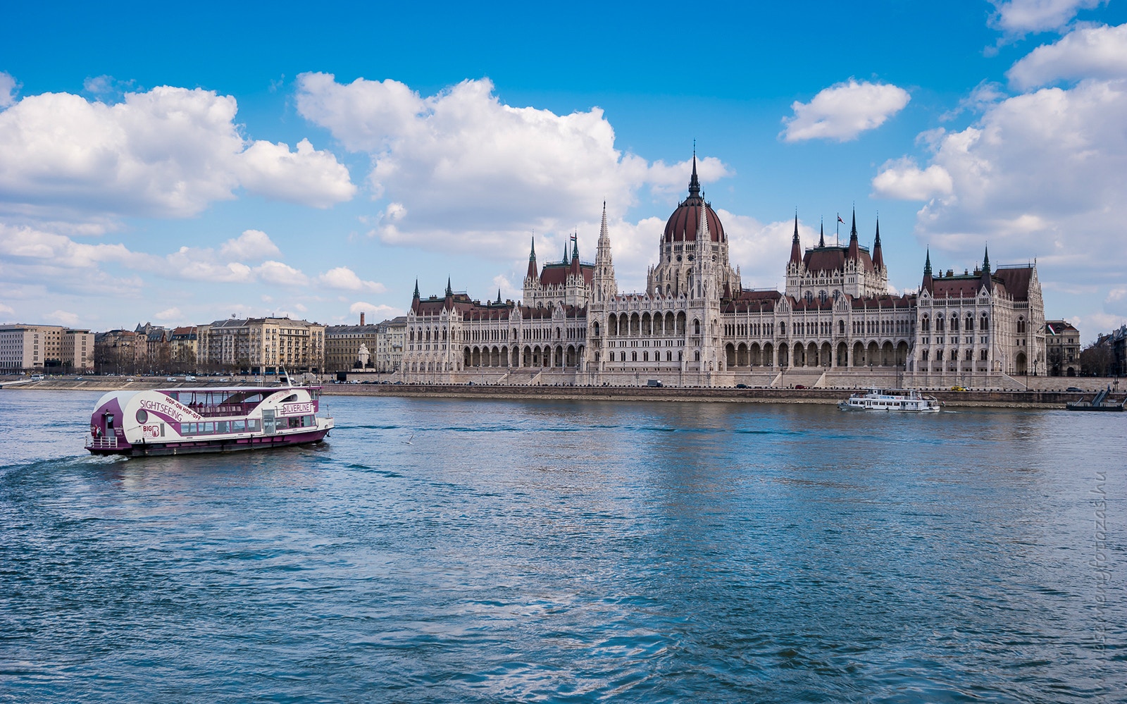 Budapest Party Boat Cruise at night with tourists enjoying unlimited drinks on the deck