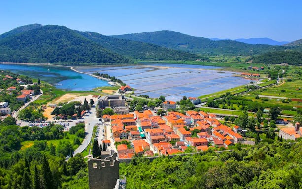 Ston town with salt pans and lush hills, part of Ston and Korcula Island day trip.