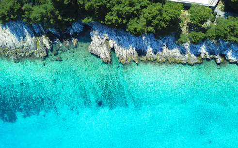 Aerial view of Blue Lagoon's turquoise waters and rocky coastline.