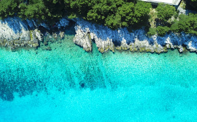 Aerial view of Blue Lagoon's turquoise waters and rocky coastline.