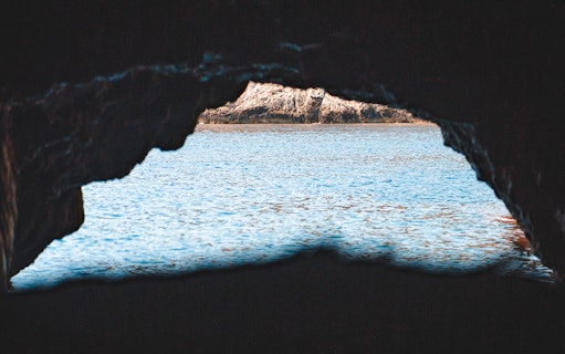 View of Blue Lagoon through a cave opening during a half-day tour.