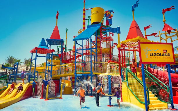 Children playing at Legoland Water Park in Dubai with colorful slides and water features.