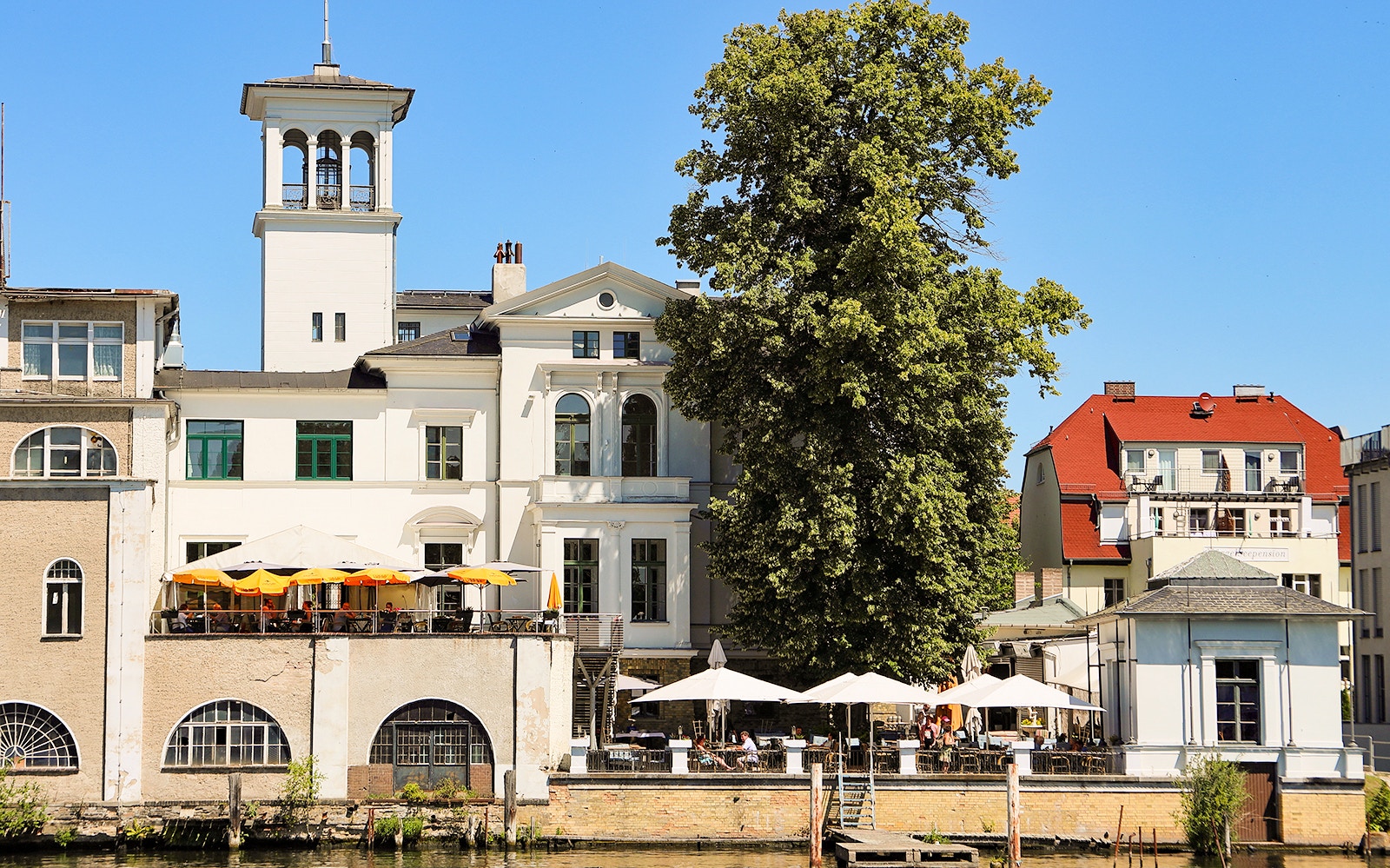 Historic lakeside building with outdoor seating on Müggelsee cruise from Berlin-Treptow.