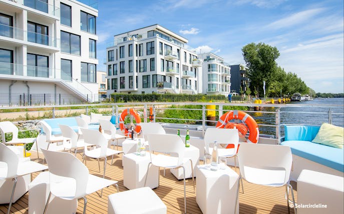 Luxury solar catamaran deck with seating, life rings, and river view near Jannowitzbrücke.