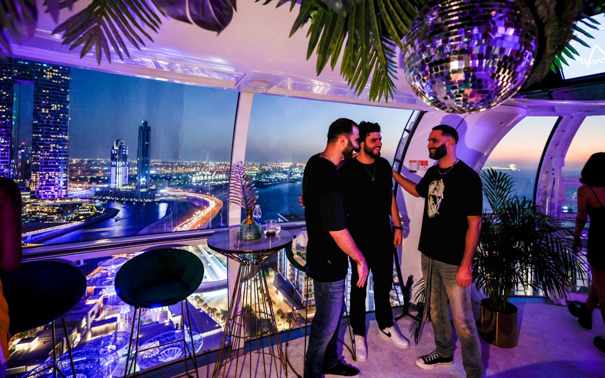 Group enjoying night view from Ain Dubai observation cabin.