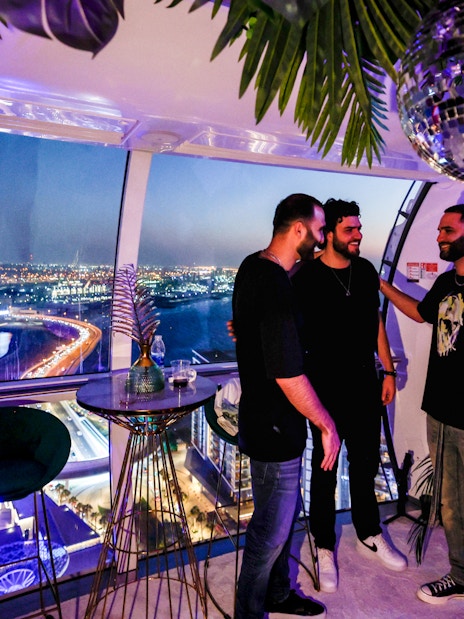 Group enjoying night view from Ain Dubai observation cabin.