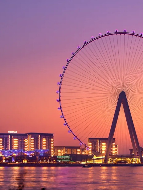 Ain Dubai Ferris wheel at sunset with city skyline in Dubai.