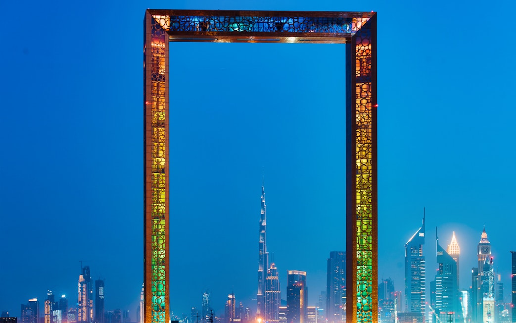 Dubai Frame with city skyline at dusk, featuring Burj Khalifa in the background.