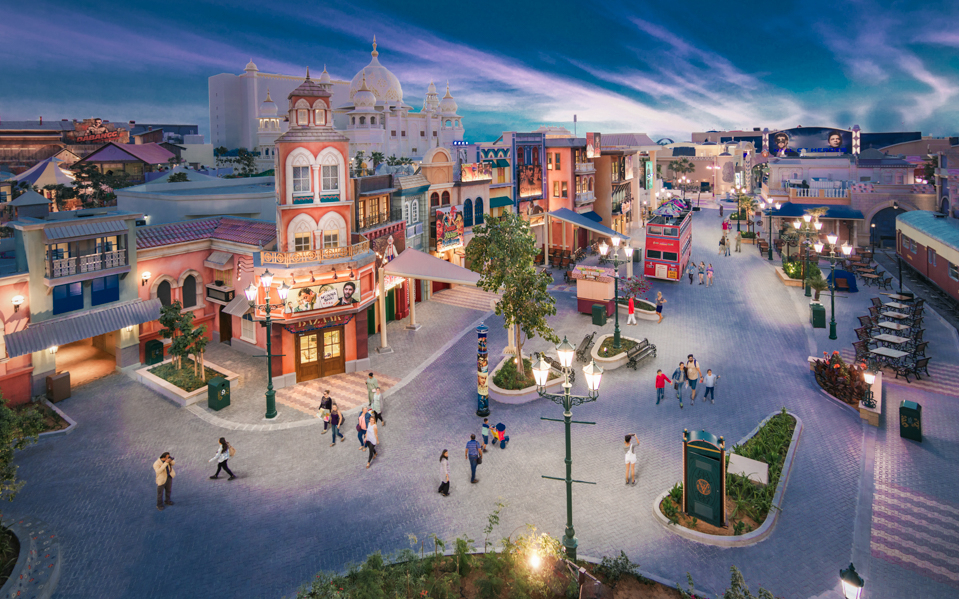 Bollywood Parks Dubai vibrant street scene with colorful buildings and visitors.
